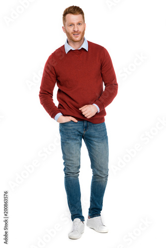 full length view of handsome redhead man looking at camera isolated on white