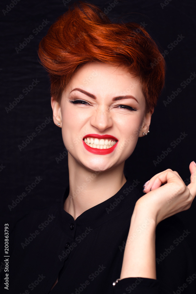 Portrait of a beautiful young red-haired woman with short hair on a dark background