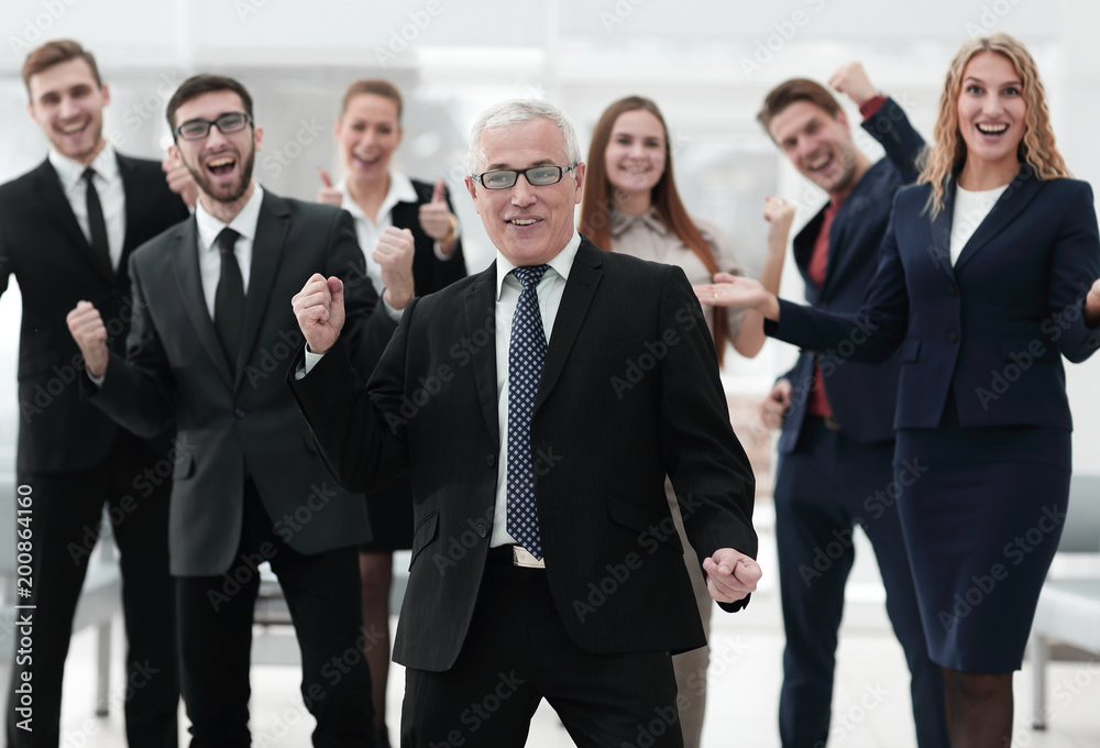 happy senior businessman and triumphant business team happy senior businessman and triumphant business team