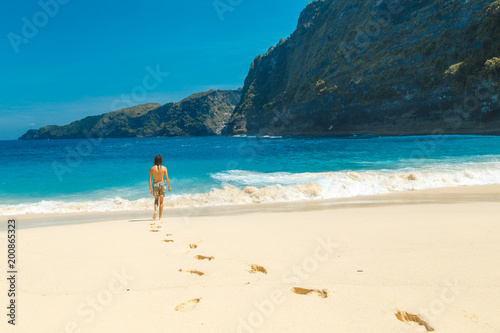 Male on hot summers day on beach going for a swim in ocean