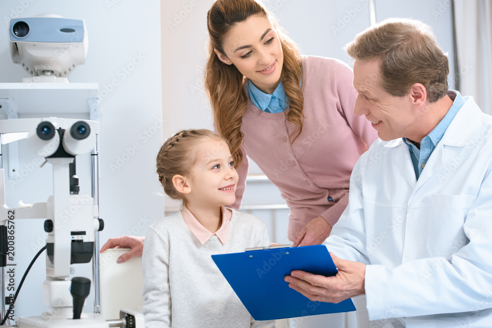 smiling ophthalmologist showing something to patient in clipboard smiling ophthalmologist showing something to patient in clipboard