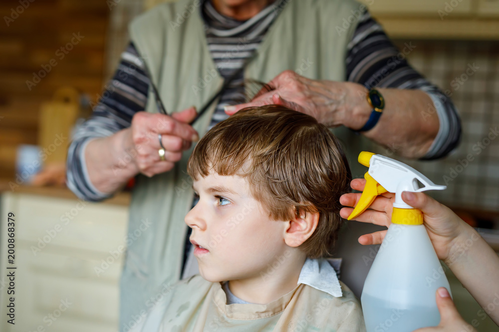 Beautiful kid boy with blond hairs getting his first haircut. Beautiful kid boy with blond hairs getting his first haircut.
