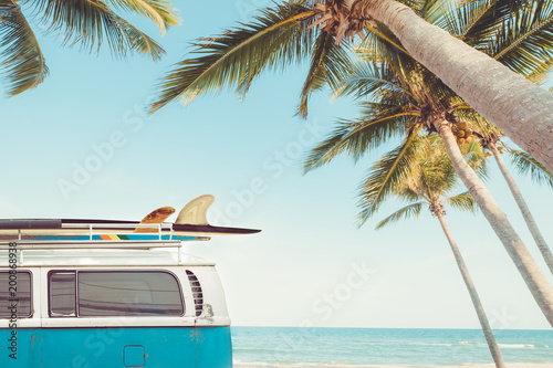 Fototapeta Naklejka Na Ścianę i Meble -  vintage car parked on the tropical beach (seaside) with a surfboard on the roof - Leisure trip in the summer. retro color effect