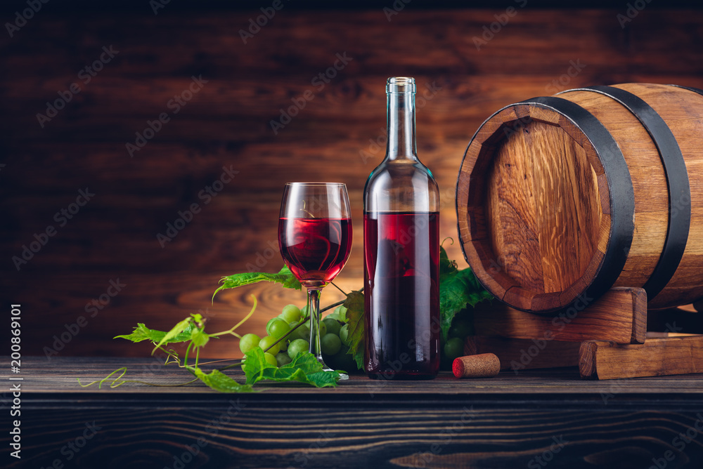 Wine bottle and glasses with wooden barrel on the table