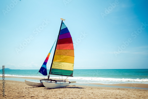 Leinwand Poster Colorful sailboat on tropical beach in summer.