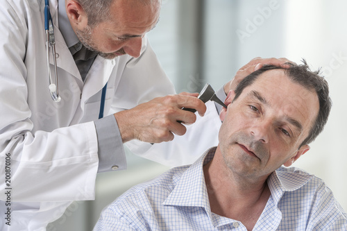 Mature man at medical examination, otoscopy
