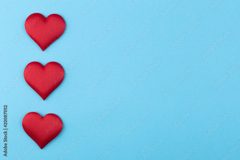 Decorative colourful sponge is small heart blue background. Many colorful silk hearts - valentine background