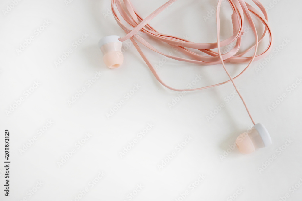 Top view, soft pink earphone on white background.
