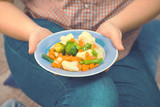Girl with a plate of vegetables in hands. Healthy eating concept. Proper nutrition. Vegetarian food. Vegans food. Toned image.
