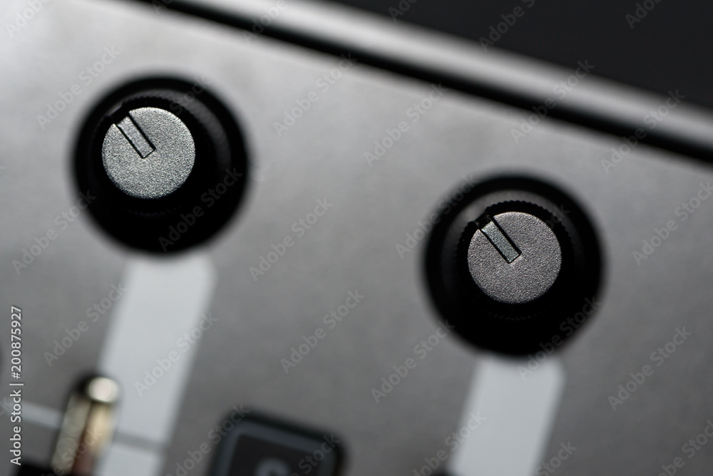 Macro close up of audio studio mixer volume level sliders and dials short depth of field selective focus Macro close up of audio studio mixer volume level sliders and dials short depth of field selective focus