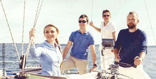 Group of friends on a yacht enjoying a good summer day. Vacation, holiday, summertime concept.