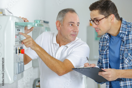 technician and apprentice fixing a photocopier machine