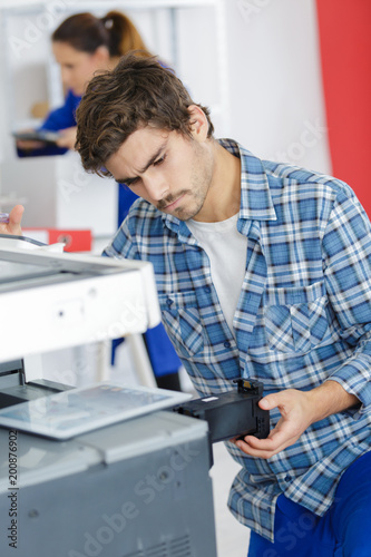 young man fixing printer