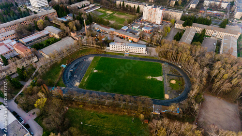 Aerial view of the city stadium among the buildings.