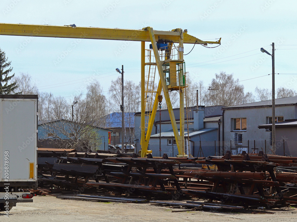 Warehouse and distribution of metal products under the open sky. Loading rail crane and car in the warehouse. Metallurgical branch. Building bussiness.