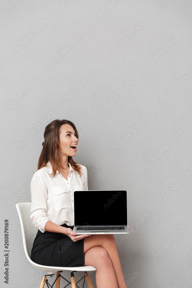 Emotional happy young business woman showing display of laptop computer. Emotional happy young business woman showing display of laptop computer.