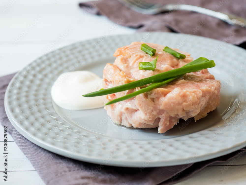 Canned tuna in its own juice with green onions on a plate. selective focus