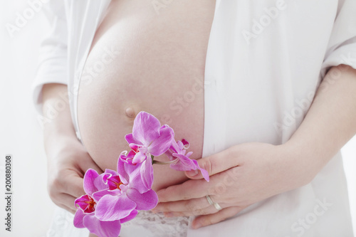 pregnant women with orchids on white background