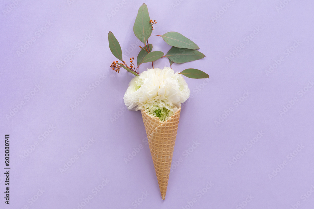 Fototapeta View from above of waffle cone with flower composition on lilac background with copy space, flat lay