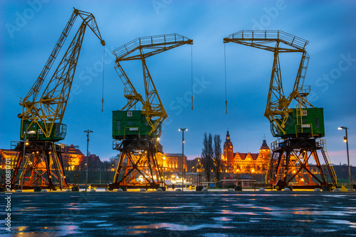 Historical harbor cranes on riverside boulevards in the evening, after a spring downpour photo