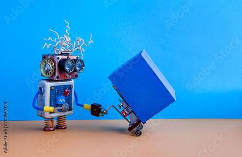 Robotic logistic delivery service concept. Robot moving big container with powered pallet jack. Forklift cart mechanism on brown floor, blue wall background. Copy space on cardboard box