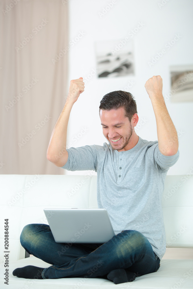 man with a winning gesture in front of the laptop man with a winning gesture in front of the laptop