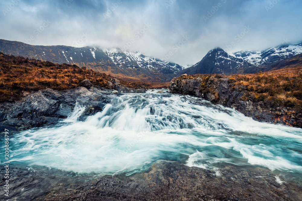 Fototapeta premium Waterfall and mountain at Fairy Pool in Isle of Skye, Scotland