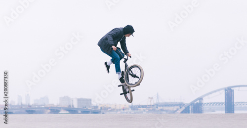 Leinwand Poster BMX rider makes a TAilwhip trick