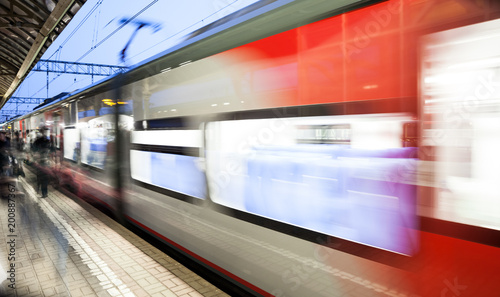 Motion blurred speed moving railroad train at railway station platform