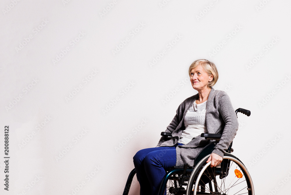 Portrait of a senior woman with wheelchair in studio. Portrait of a senior woman with wheelchair in studio.