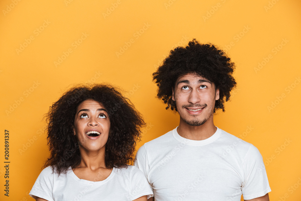 Portrait of a joyful young afro american couple looking up Portrait of a joyful young afro american couple looking up