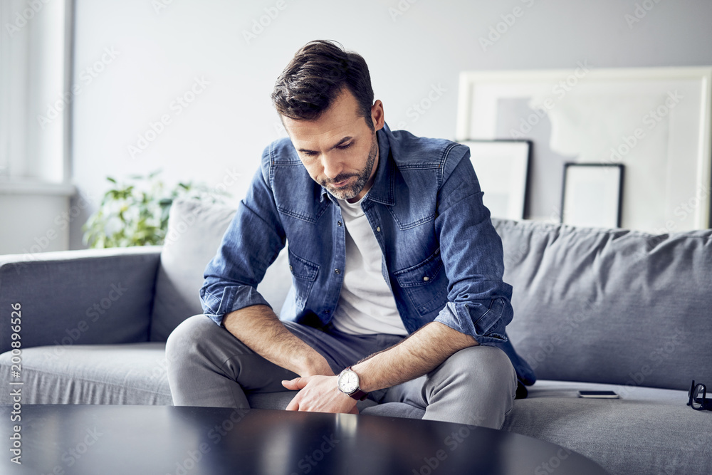 Worried sad man sitting on sofa Worried sad man sitting on sofa