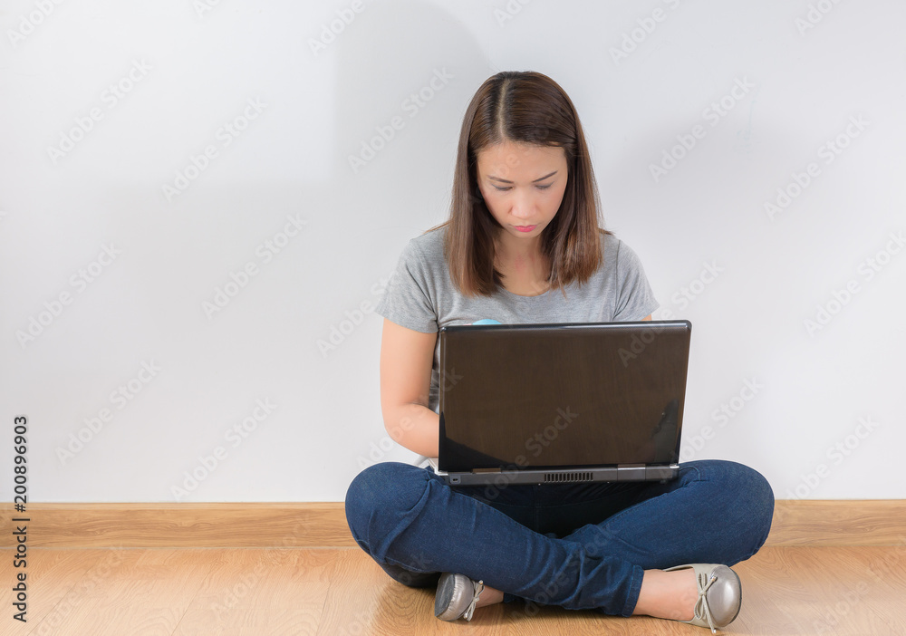 young woman sitting on the floor with crossed legs and using laptop young woman sitting on the floor with crossed legs and using laptop