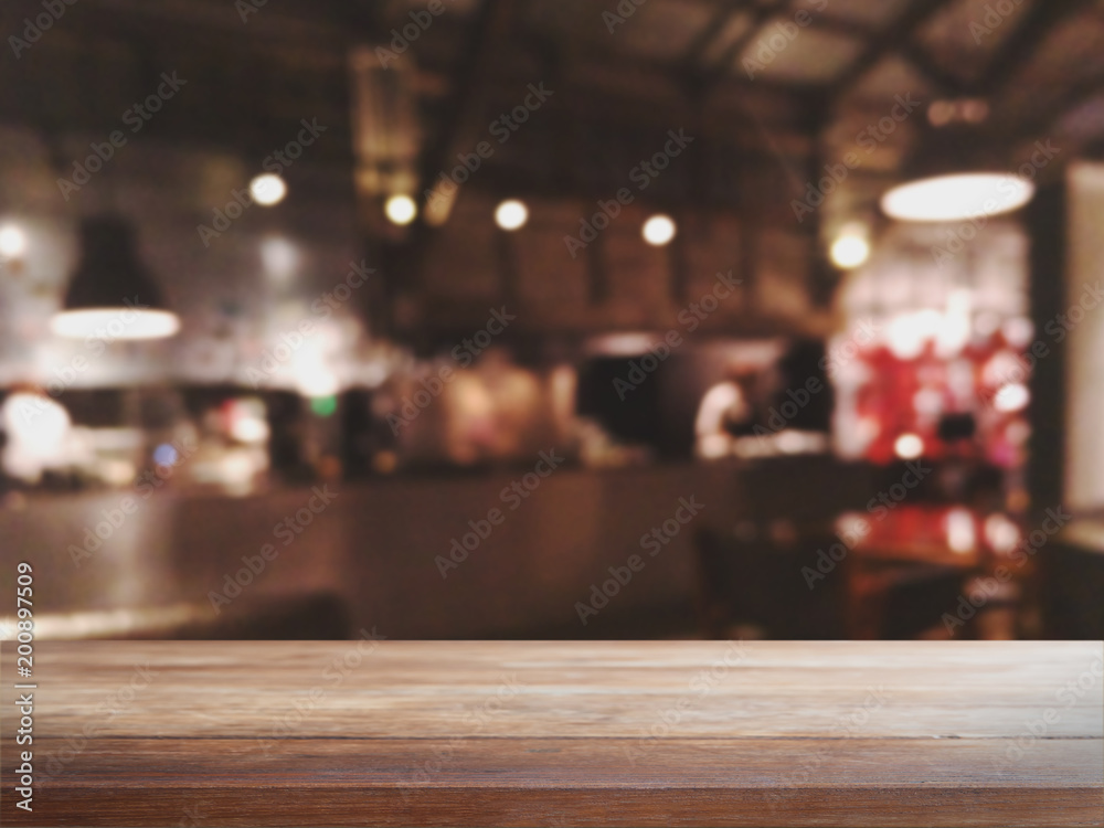 Empty wood table top and blurred bokeh cafe and coffee shop interior background with vintage filter - can used for display or montage your products.