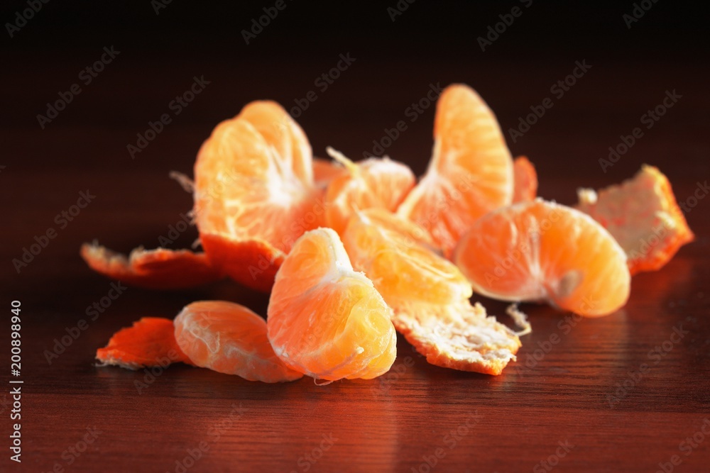 Orange peel mandarines on a dark background on a wooden table. Tropical fruits. Closeup for concept design. Orange peel mandarines on a dark background on a wooden table. Tropical fruits. Closeup for concept design.