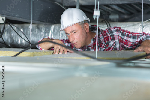 man repairing electrical wiring on the ceiling