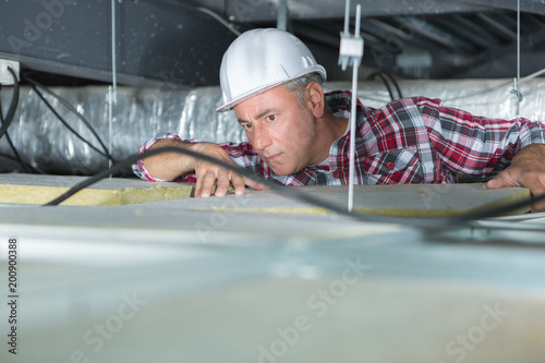 man repairing electrical wiring on the ceiling photo