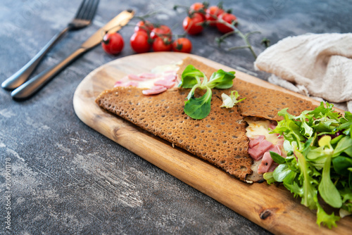 Konstfotografi Black wheat and wheat galette topped with cooked ham and emmental cheese