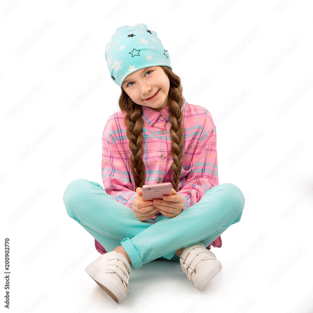 Happy little girl with smartphone sitting on floor isolated on white background. People, children, technology concept