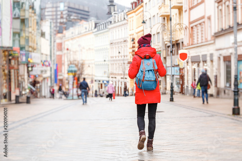 Happy young urban woman walking in european city photo