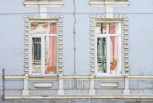 Reflections in the windows of an old house. Fragment of the facade. The picture was taken in Russia  in the city of Orenburg. 04 07 2018