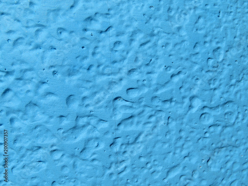 Blue wall texture background. Wall fragment with cracks and dents