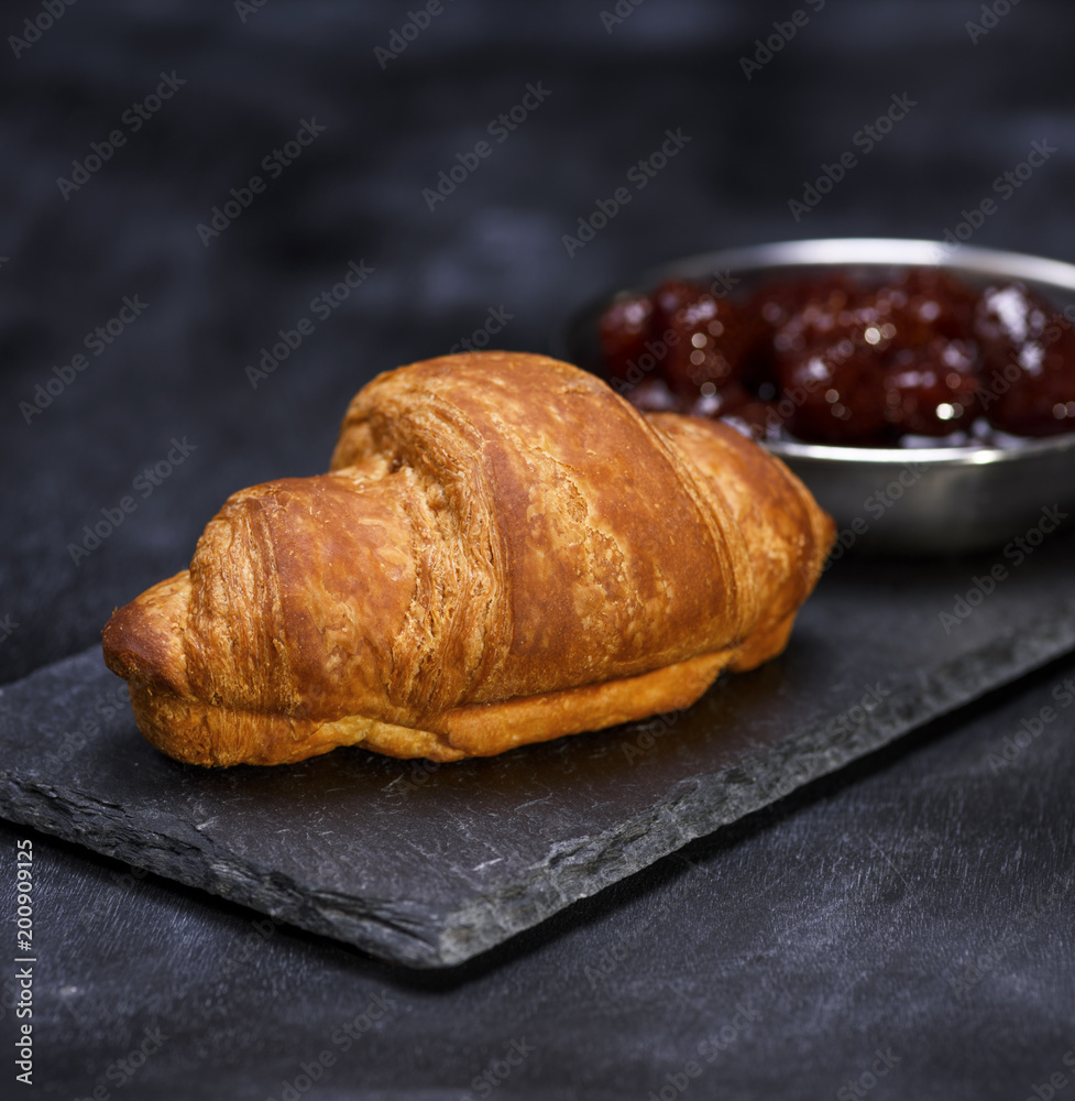 baked croissant on a black graphite background