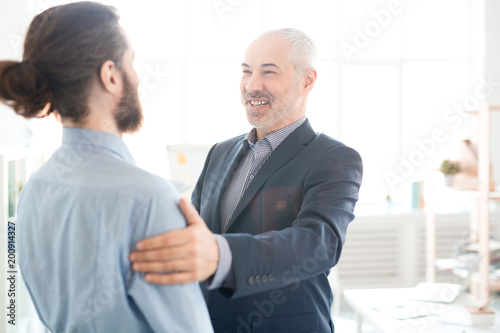 Mature executive congratulating his partner with good work