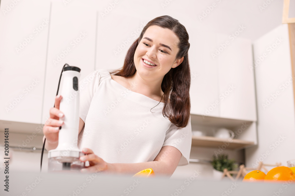 Healthy lifestyle. Low angle of merry gay woman using blender and smiling Healthy lifestyle. Low angle of merry gay woman using blender and smiling