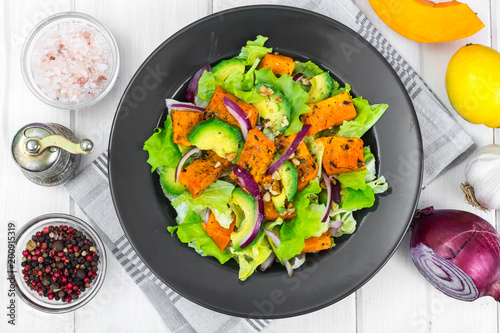 Delicious salad with avocado, pumpkin, greens