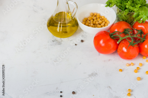 Olive oil, green salad lettuce, chickpea and fresh tomato, copy space