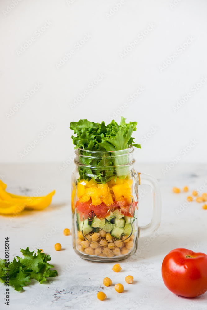 Salad in a jar. Homemade healthy salad from chickpea, tomato, yellow paprika, cucumber and green lettuce Salad in a jar. Homemade healthy salad from chickpea, tomato, yellow paprika, cucumber and green lettuce