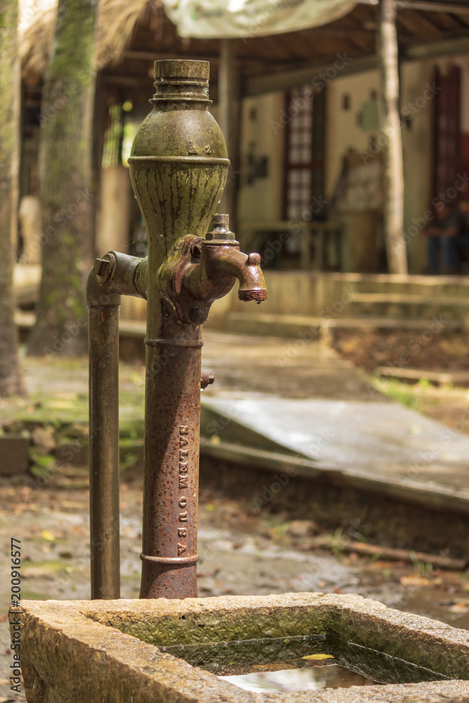 Old colonial water pump in mexican town. Although its parts are still standing, it is now rusty and out of order. Quiet spring showers make it wet and even more beautiful Old colonial water pump in mexican town. Although its parts are still standing, it is now rusty and out of order. Quiet spring showers make it wet and even more beautiful