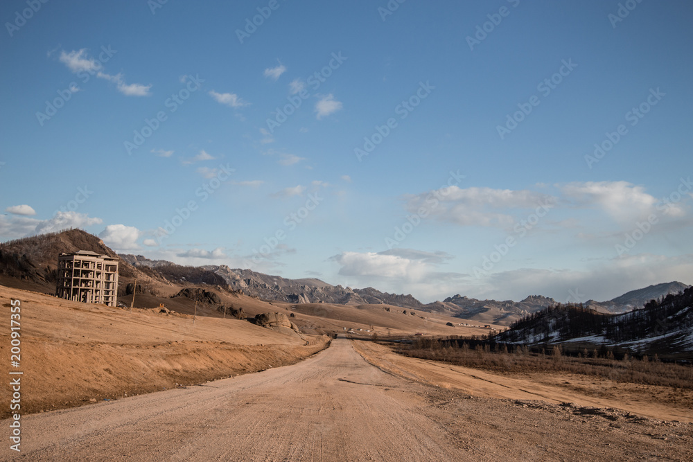 Obraz premium Sand road track outside country with mountain and blue sky
